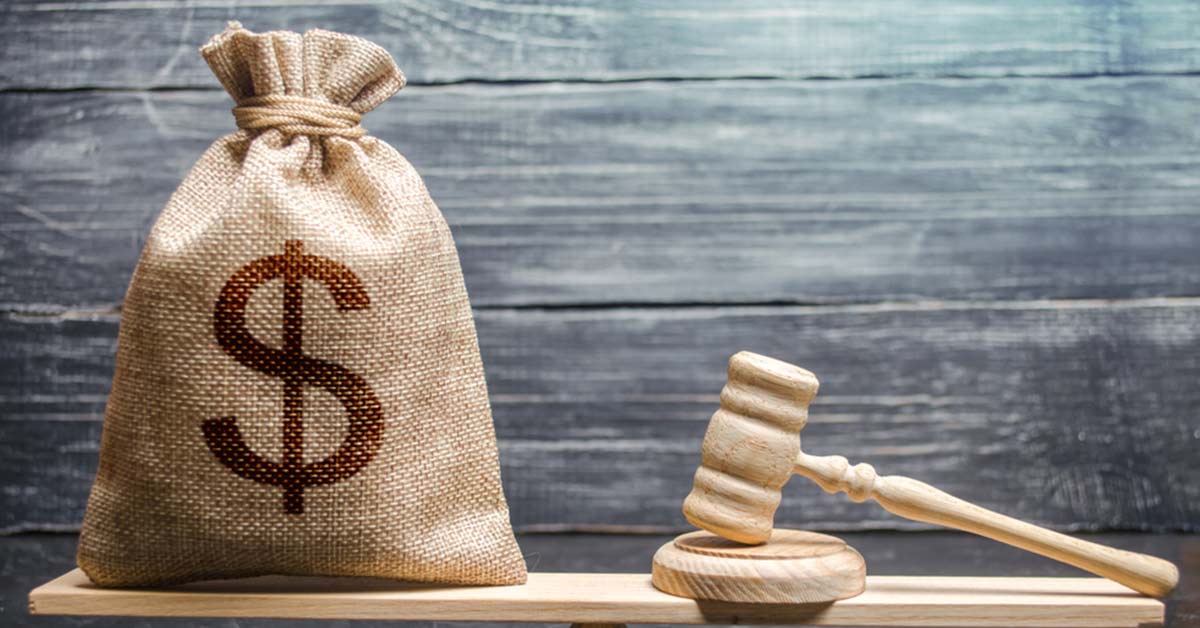 A sack of money next to a judge's gavel on a table