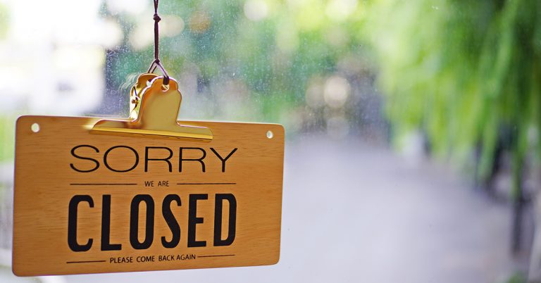 A sign on a glass door displaying, Sorry we are Closed, Please come abck again.