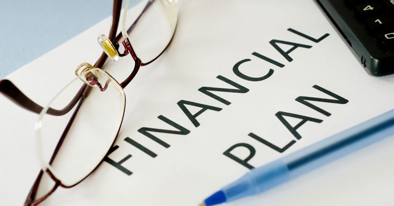 a pair of glasses and a pen on a note pad that says financial plan