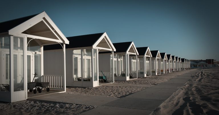 Row of identical beach rental houses on a bright clear day.